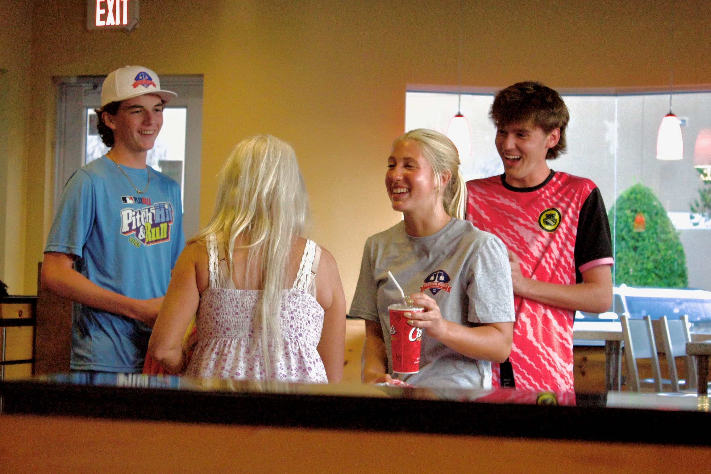 A group of kids conversing at the Justice Field Day event at Raising Canes